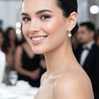 Close-up of an ear wearing pearl earrings with a neutral background