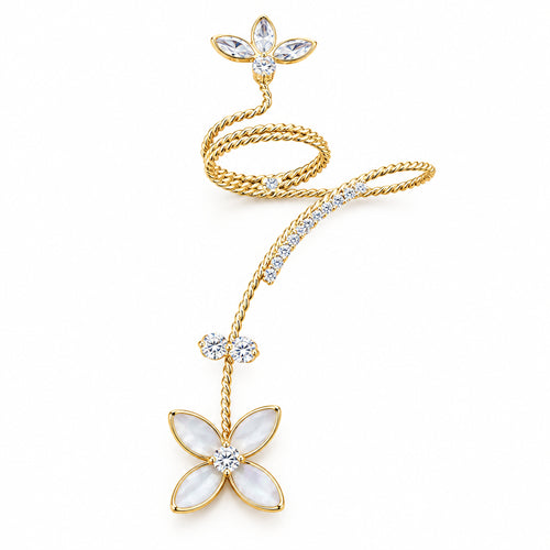 A gold-toned floral hair claw clip with white mother-of-pearl flower petals and clear rhinestone accents, displayed on a solid dark purple background.