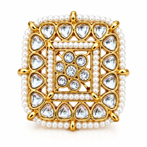 A square gold-plated ring with intricate white bead borders and clear teardrop-shaped stones, set against a solid red background.