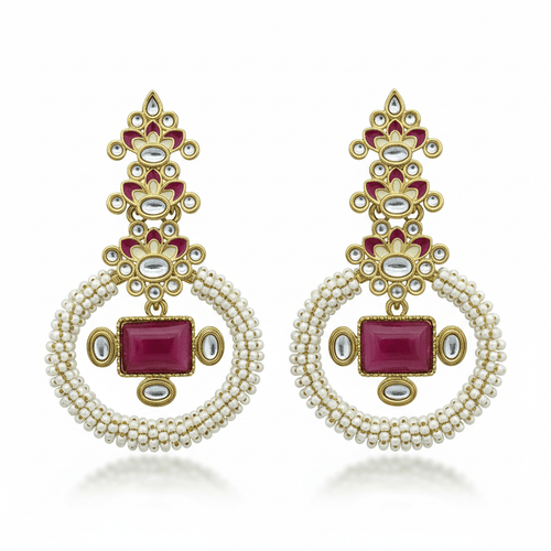 A pair of ornate gold-toned dangle earrings with white pearl-like bead loops, red rectangular and oval stones, and small clear stones, displayed on a solid green background.